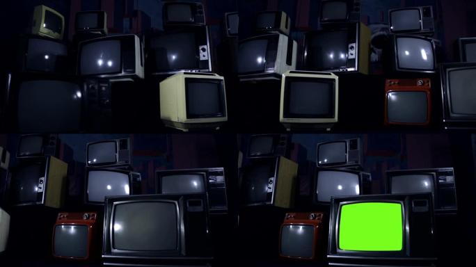 旧电视打开绿色屏幕，在一堆许多旧电视中。深色。