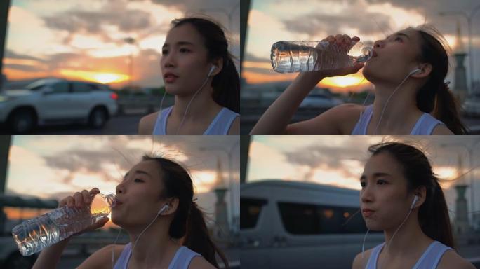 年轻的亚洲运动员女子跑步后喝水，慢动作