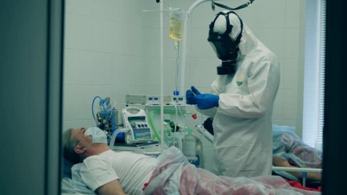 冠状病毒大流行，2019-ncov，冠状病毒的概念。穿着防护服的医务人员正在给病人进行静脉注射