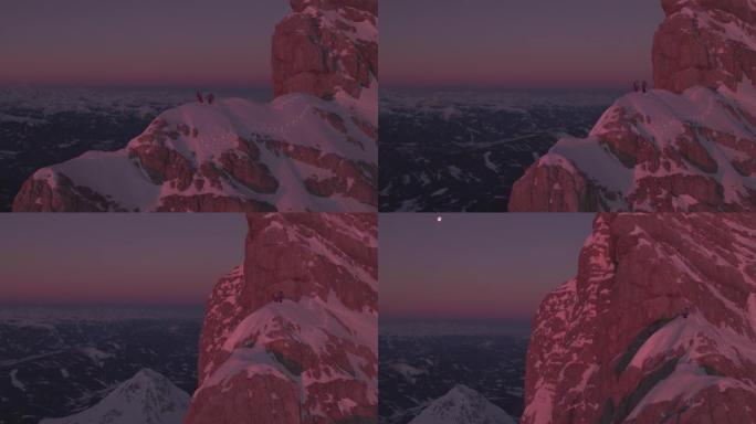 日出时站在白雪覆盖的山脊上的雄性