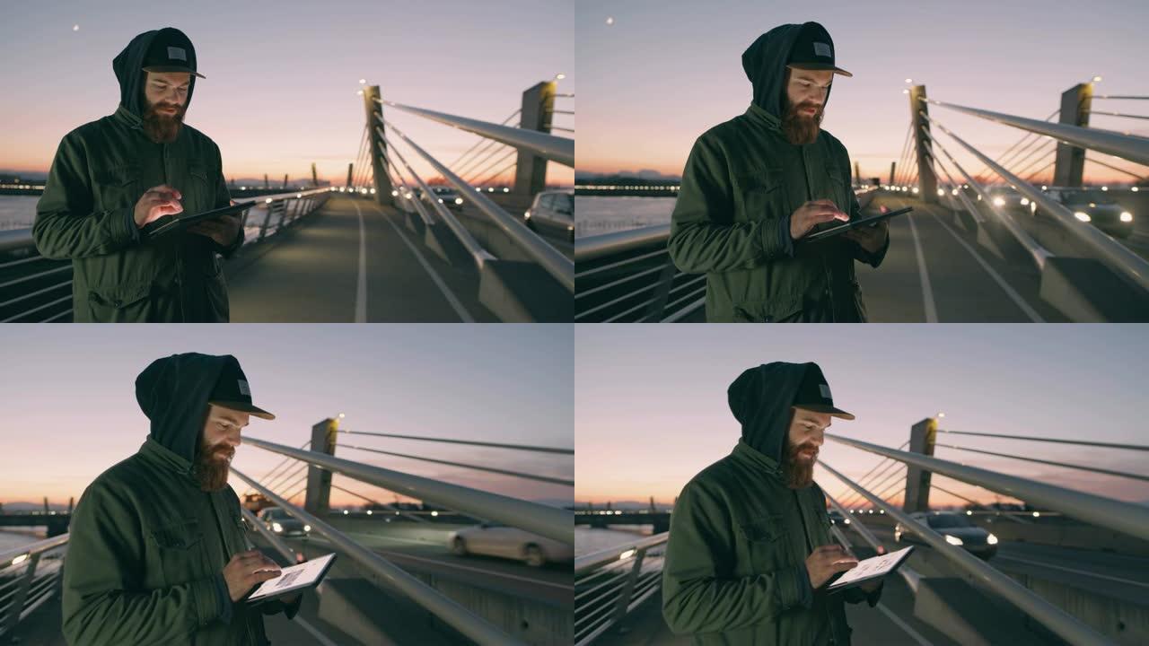 Man女士在黄昏时在桥上使用数字平板电脑