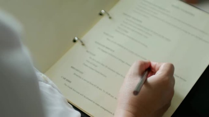 女人用笔在记事本上写字，在家工作