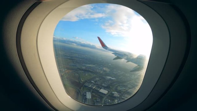 在城市上空飞行时从窗户看到飞机机翼