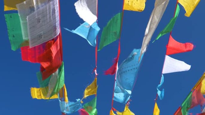 自下而上: 在吹过西藏的风中悬挂在绳索上的祈祷旗