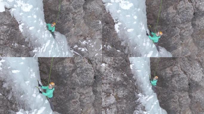 无人机: 女登山者在攀登冰冷的瀑布时放置冰镐。