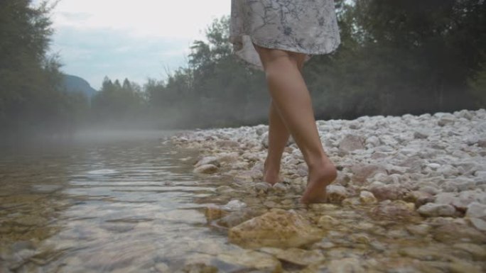SLO MO赤脚女人在溪流中行走
