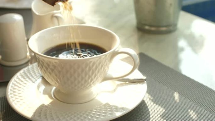 将糖倒入咖啡中杯子特写冲泡白色杯子