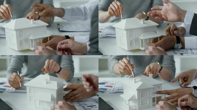讨论房屋模型的建筑师之手