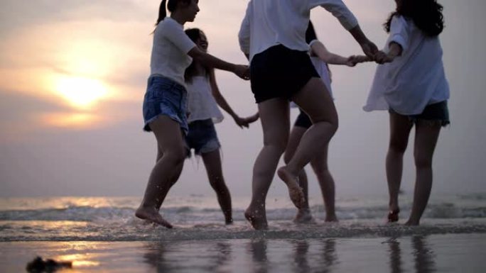 一群青少年在日落时分在海滩上快乐有趣