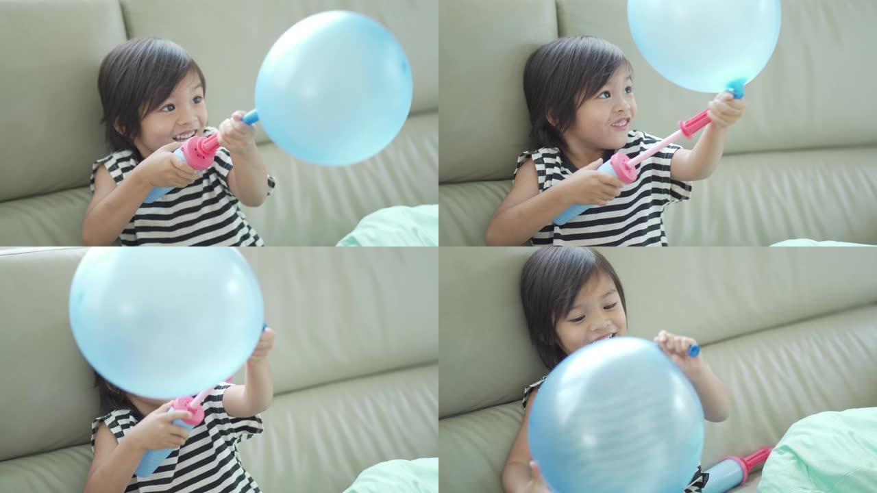 快乐的小男孩在室内用玩具泵吹气球。