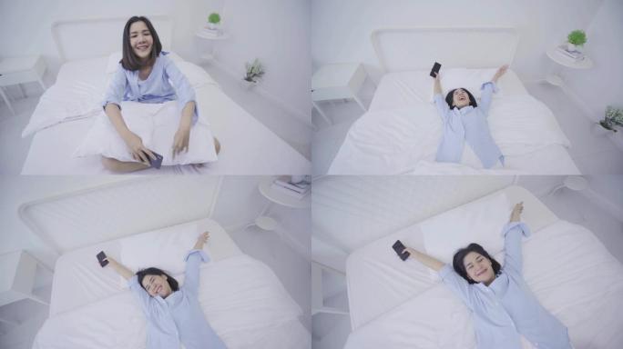 4k分辨率美丽有趣的亚洲女人使用智能手机躺在床上