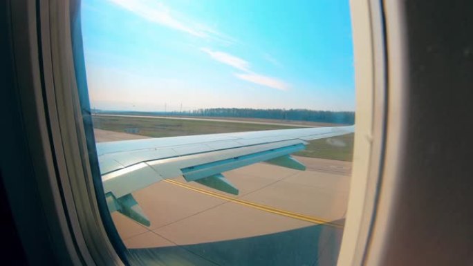 飞机在跑道上行驶，从机舱窗户可以看到。