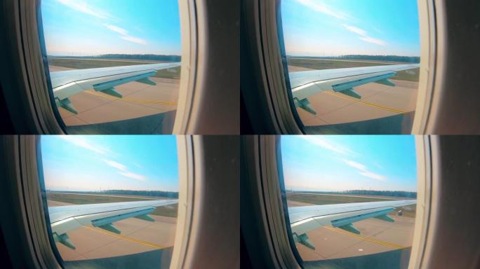 飞机在跑道上行驶，从机舱窗户可以看到。