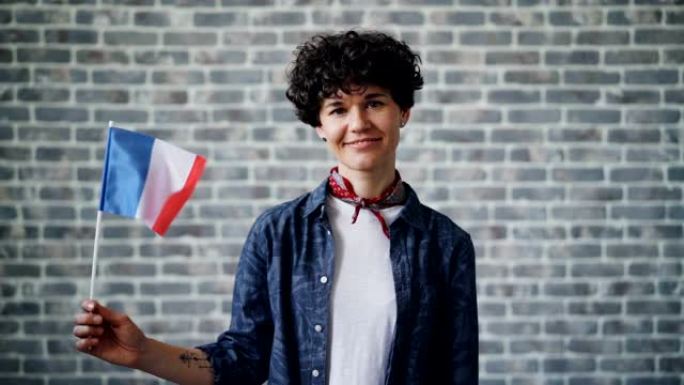 慢动作肖像的法国女士举着法国的官方旗帜和微笑