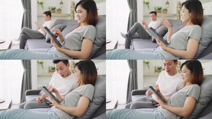 4K UHD: 亚洲夫妇在客厅沙发上使用智能手机。