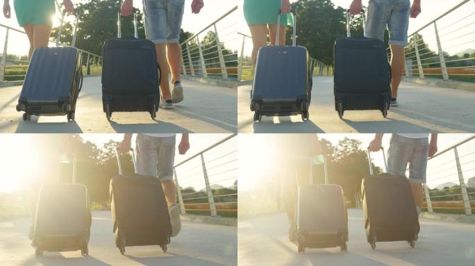 镜头耀斑: 无法识别的新婚夫妇在前往机场的途中拖着行李。