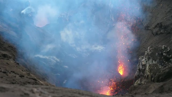 特写: 太平洋上的活火山喷出了发光的橙色熔岩。