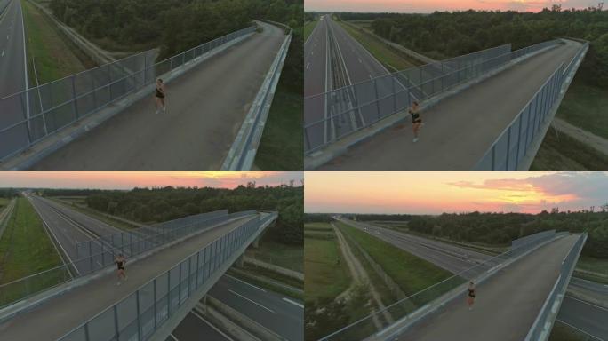 空中女子在日落时跑过桥