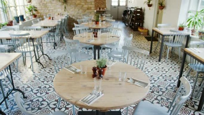 餐厅的空置设置，配有圆桌和鸭蛋蓝色椅子，白天，倾斜镜头