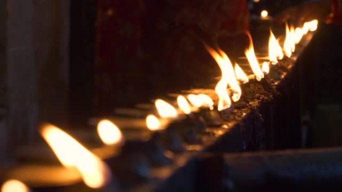特写: 人们来到印度教寺庙，点燃油蜡烛作为祭品。