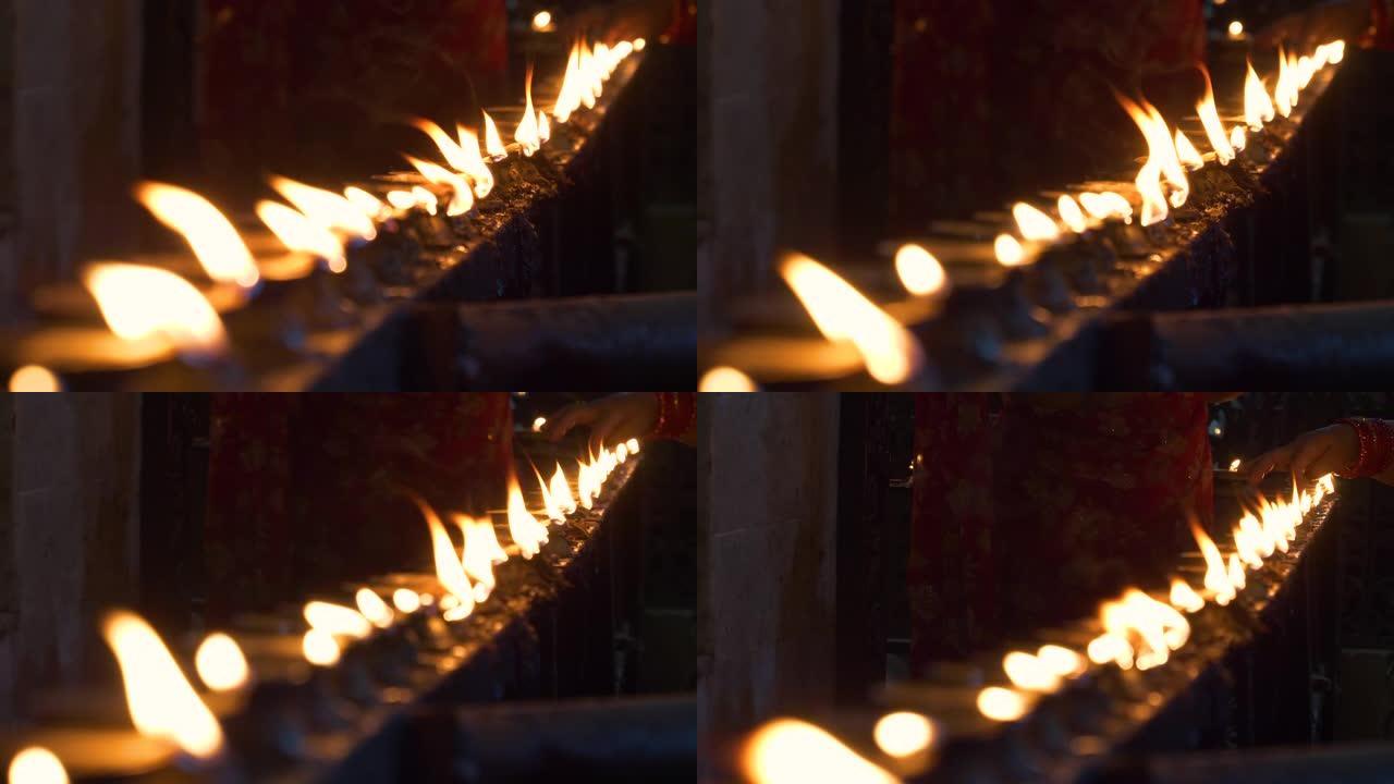 特写: 人们来到印度教寺庙，点燃油蜡烛作为祭品。