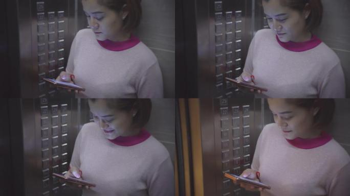 在电梯中使用智能手机的年轻女子