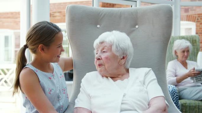孙女在参观养老院期间与祖母坐在一起聊天