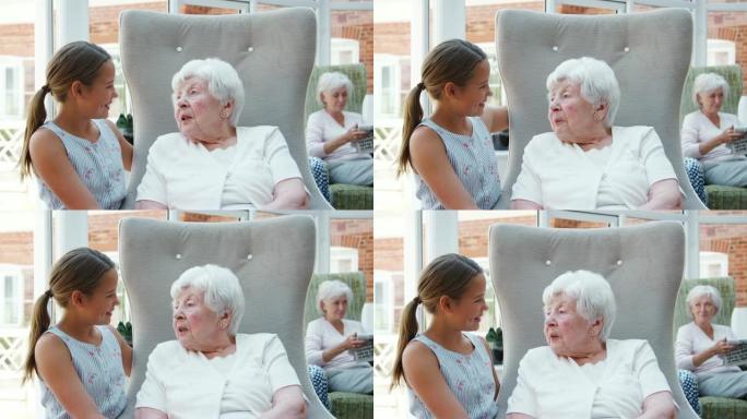 孙女在参观养老院期间与祖母坐在一起聊天