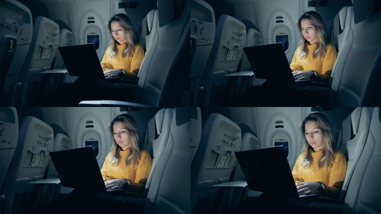 晚上与一位女士使用笔记本电脑的机舱