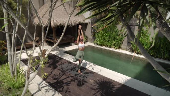 在热带后院花园做瑜伽锻炼的女人