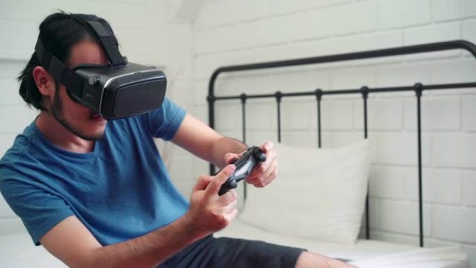 亚洲男子使用眼镜虚拟现实模拟器和操纵杆在卧室玩赛车游戏，日本男子感到快乐使用放松时间躺在家里的床上。