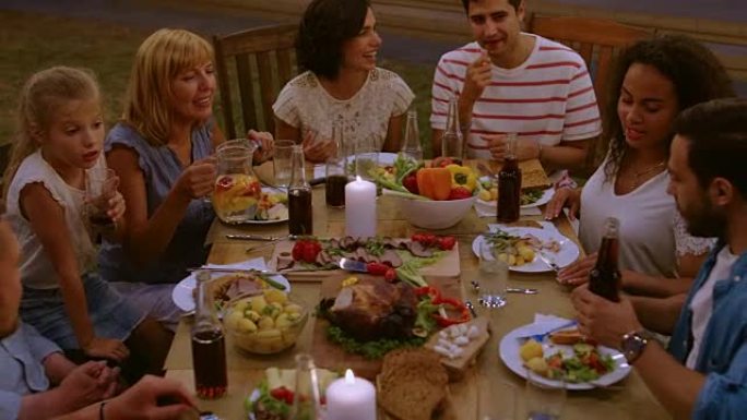 一群朋友聚集在一起的餐桌上的亲戚和朋友，年轻人和老人都在吃喝玩乐。花园派对晚会庆典。