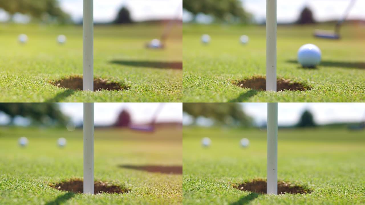 高尔夫球进入带有旗帜的洞中。