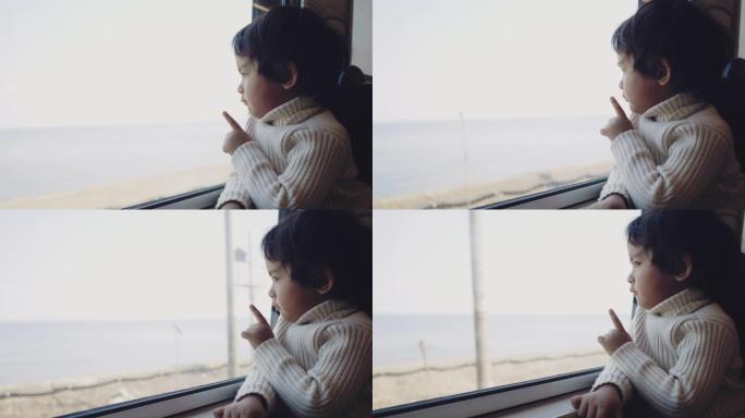 小男孩坐火车在窗外看。