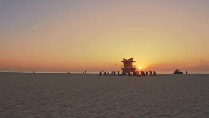 WS人在美国佛罗里达州迈阿密救生员站附近的日落海滩上练习瑜伽
