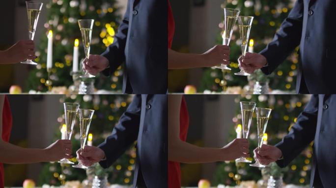 在新年晚会上无法辨认的男人和女人碰碰香槟长笛