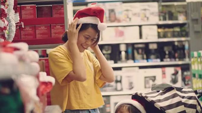 亚洲妇女和男婴在超市购物圣诞节