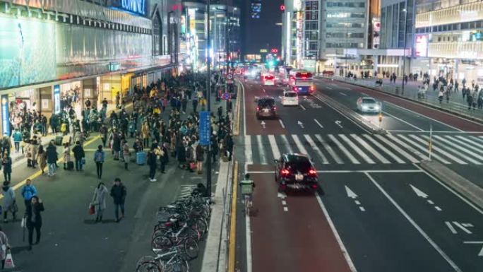 在日本新宿东京市，夜间，人群不确定的人在街上与汽车交通交叉路口行走的4k时间流逝。日本文化与购物街概