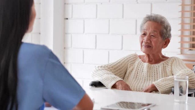 老年老妇人与年轻的黑人女护士交谈医生帮助病人在家里进行检查医疗咨询。老年奶奶听照顾者给予支持，医疗，