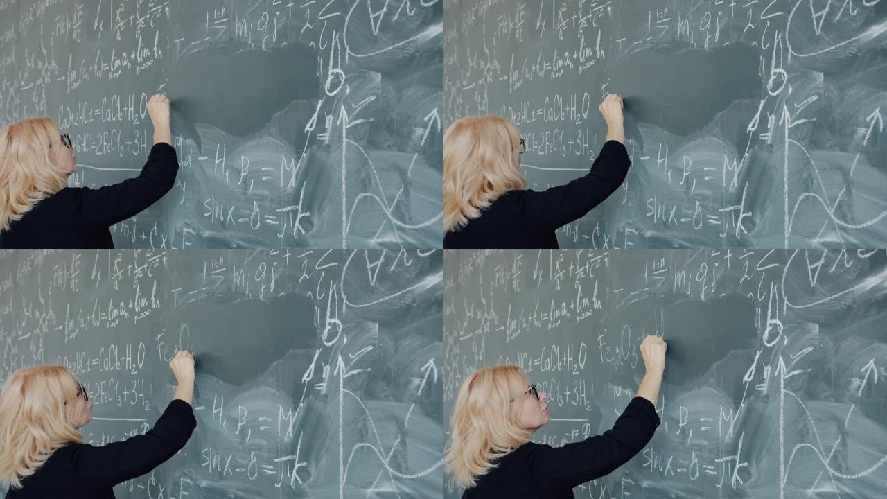 女化学老师的慢动作严肃的女人在黑板上写公式