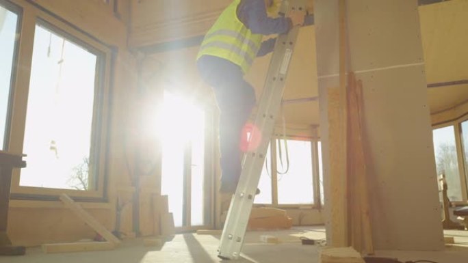 低角度: 建筑商爬上预制房屋内的梯子