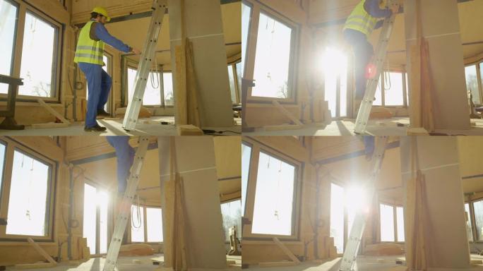 低角度: 建筑商爬上预制房屋内的梯子