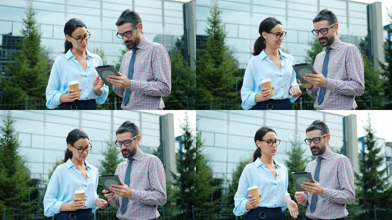 男女同事使用平板电脑在工作场所附近聊天