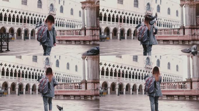 快乐美丽的高加索女游客走在老城区广场上，鸽子坐在手臂上，在威尼斯慢动作。