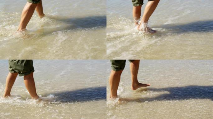 男子在阳光明媚的日子在海滩上水上行走4k
