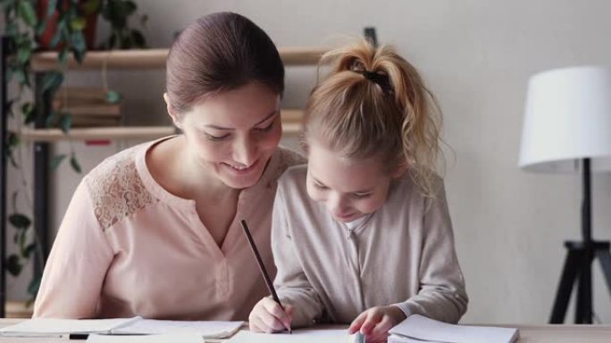 快乐的小妈妈帮助可爱的小学生女儿做作业