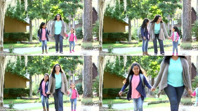 西班牙裔母亲和女儿步行上学