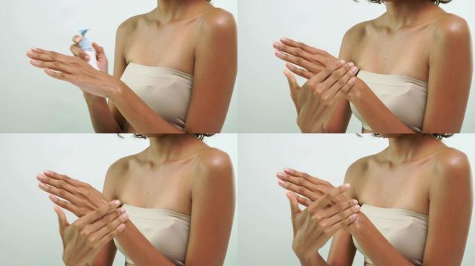 非洲女性手部摩擦皮肤的特写镜头，白色背景上的美容护肤产品。
