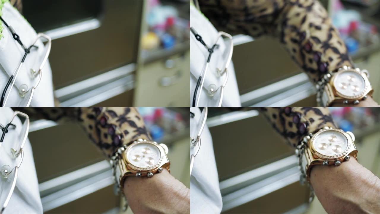 黄金手表上女性手检查时间的特写。