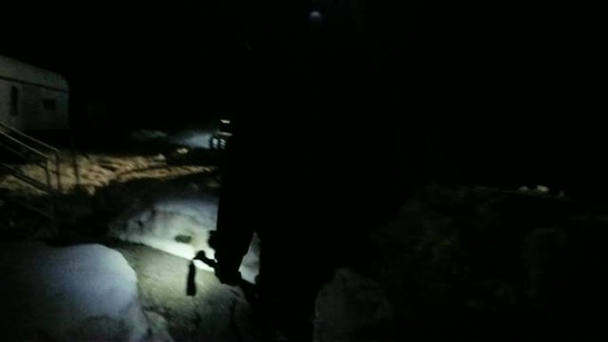 用手电筒在雪地里散步。山地大本营